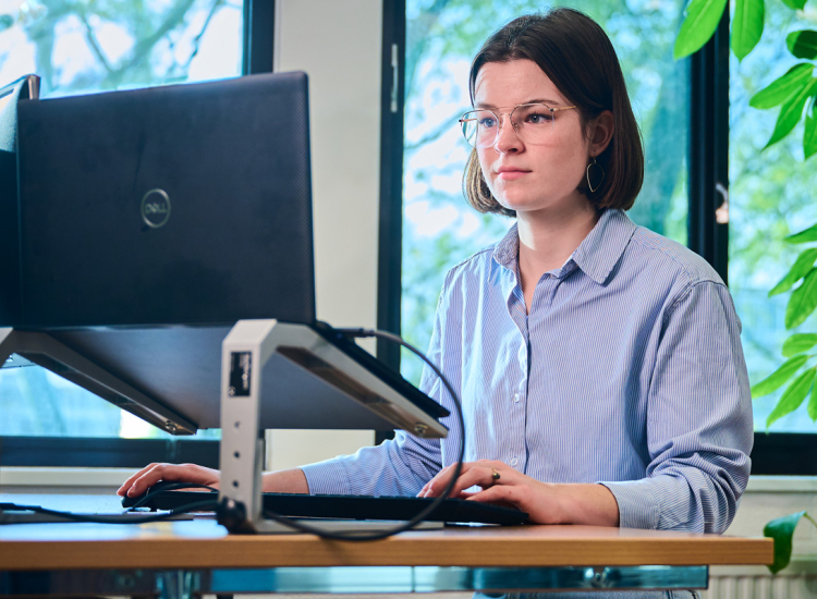 Medewerkster dienstverlening aan het werk achter een beeldscherm